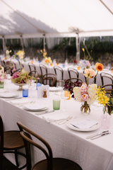 Elegant wedding reception setup with floral centerpieces and white tablecloths.